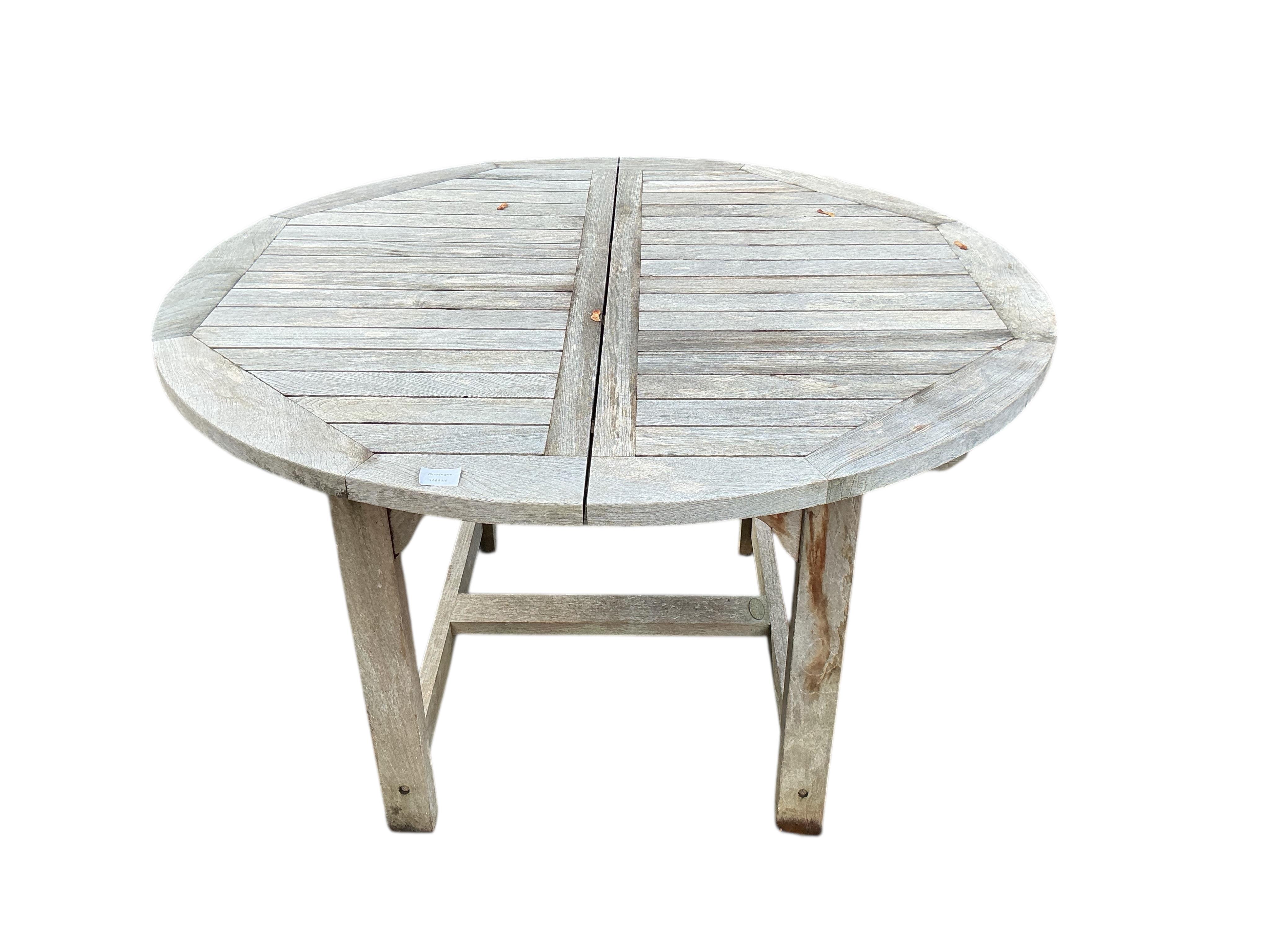 A Laidlays teak oval extending garden table, width 169cm extended, depth 120cm, height 75cm together with eight folding weathered teak garden chairs